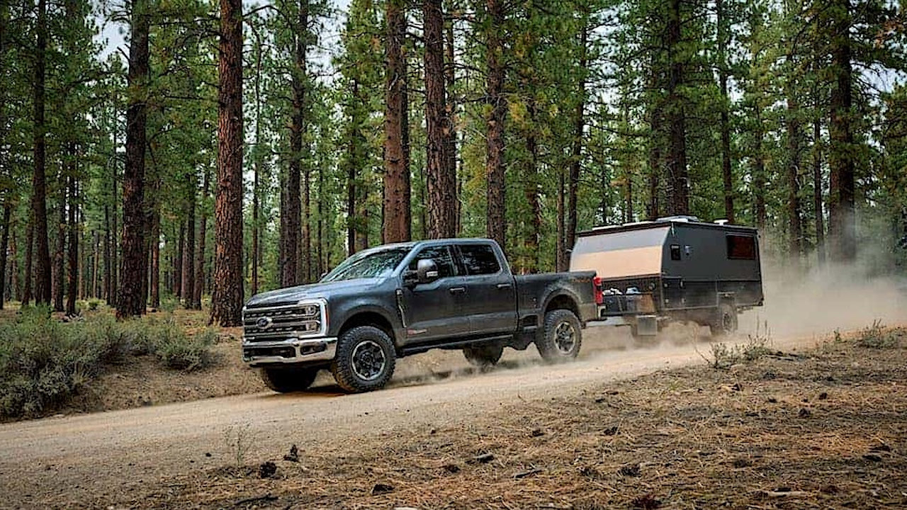 Image of Ford Super Duty 2025 towing a trailer on a forest trail.