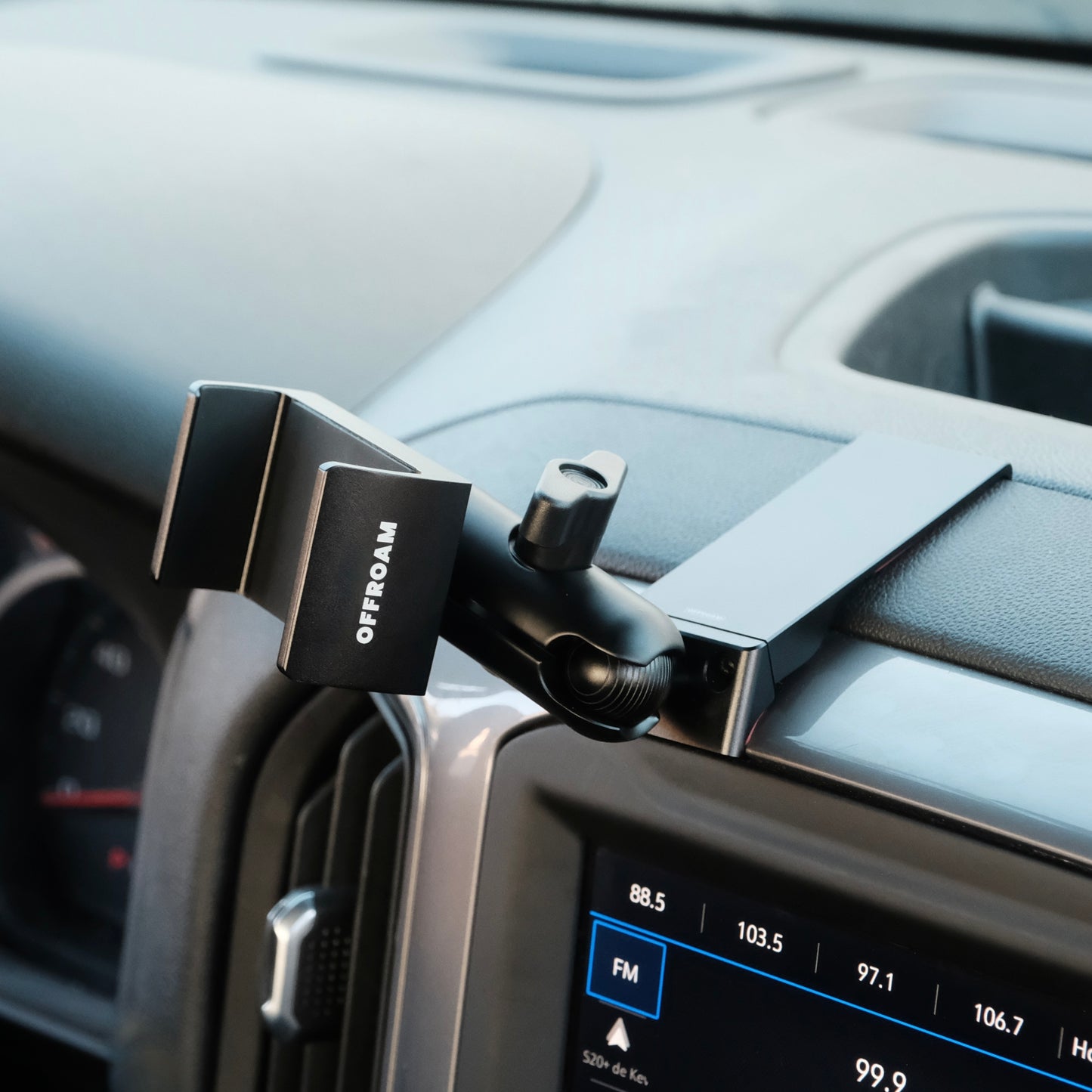 Image of Offroam Phone Mount installed securely in Chevrolet Silverado 2019-2024 | Silverado HD 2020-2024 and GMC Sierra 1500 2019-2021 | Sierra HD 2020-2023 with 7-in.|8-in. display. This premium phone mount installs easily without drilling or glue. Spring loaded Universal holder for use with any phone. Perfect placement without blocking screens, driver view, or air flow. Fully adjustable positioning.