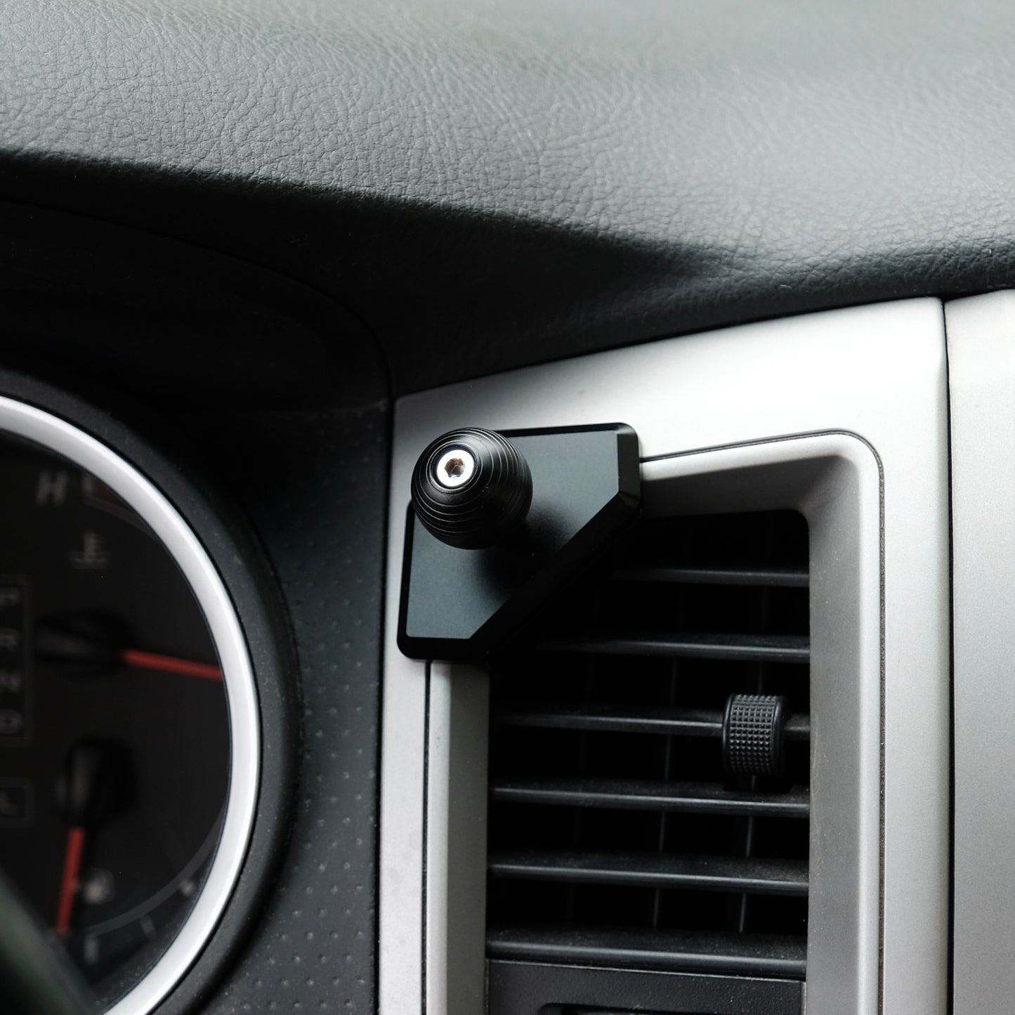 Image of Offroam Mounting Base installed securely in Toyota Tacoma 2005-2011. This premium all metal phone mounting base installs easily without drilling or glue. Perfect placement without blocking screens, driver view, or air flow.