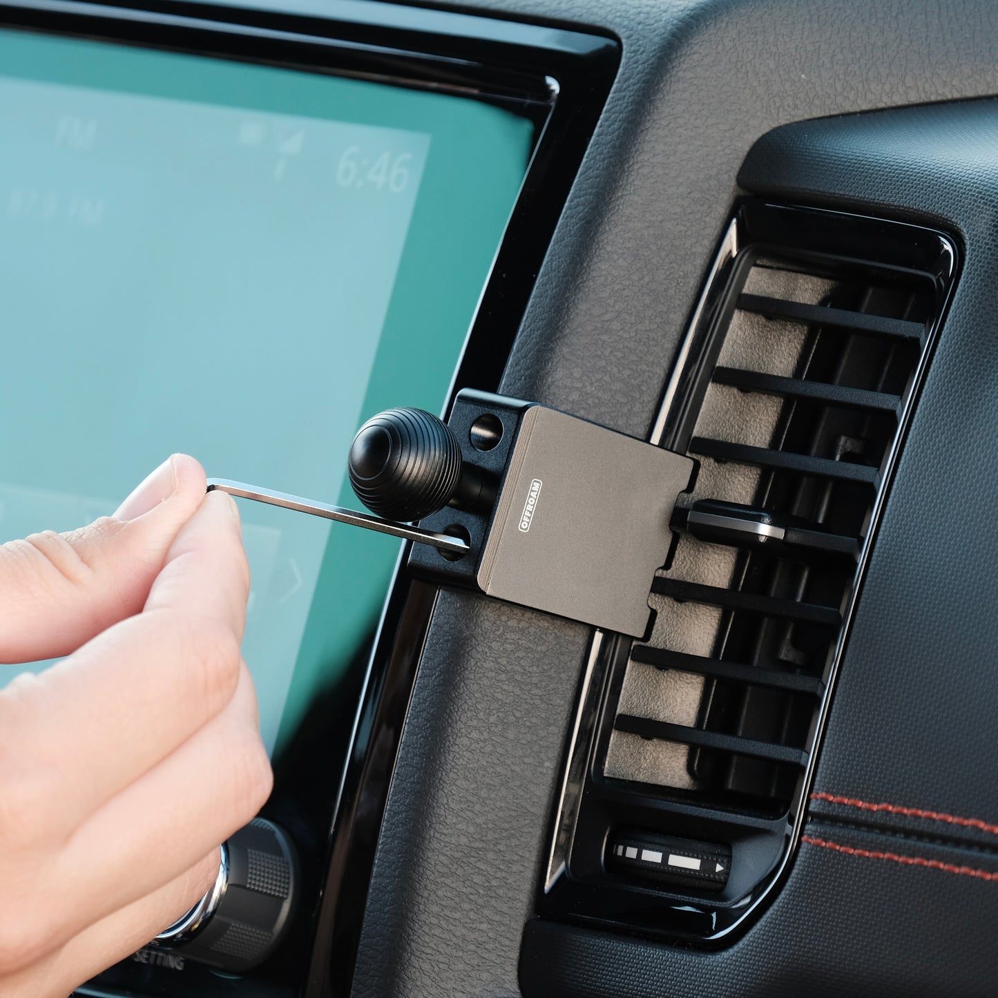 Image of Offroam Mounting Base installed securely in Nissan Frontier 2022-2024. This premium all metal phone mounting base installs easily without drilling or glue. Perfect placement without blocking screens, driver view, or air flow.