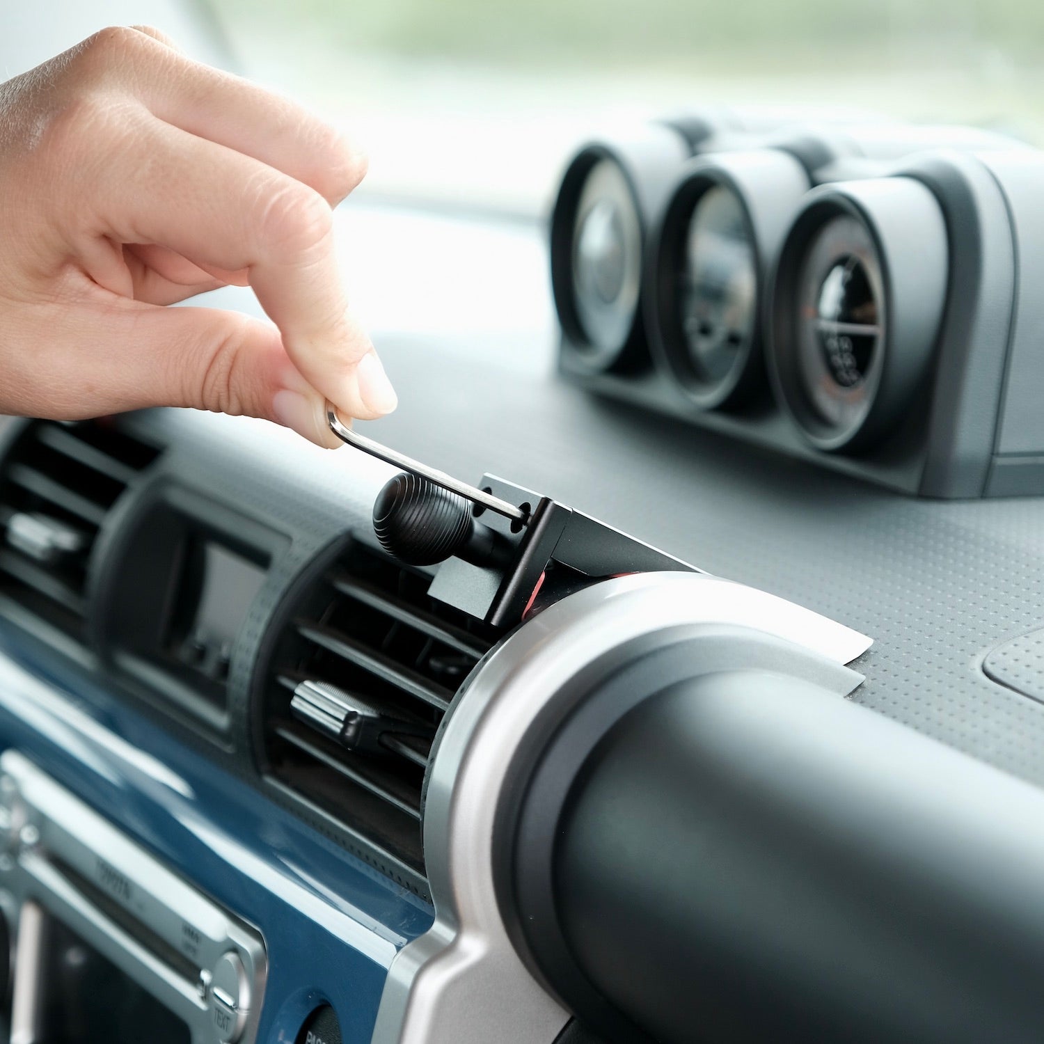 Image of Offroam Mounting Base installed securely in Toyota FJ Cruiser 2007-2014. This premium all metal phone mounting base installs easily without drilling or glue. Perfect placement without blocking screens, driver view, or air flow.