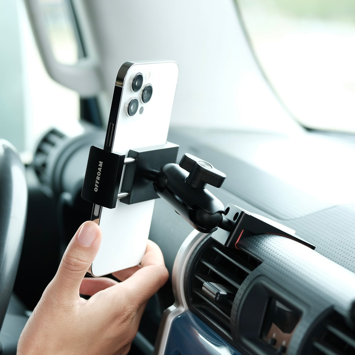 Image of Offroam Phone Mount installed securely in Toyota FJ Cruiser 2007-2014. This premium phone mount installs easily without drilling or glue. Spring loaded Universal holder for use with any phone. Perfect placement without blocking screens, driver view, or air flow. Fully adjustable positioning.