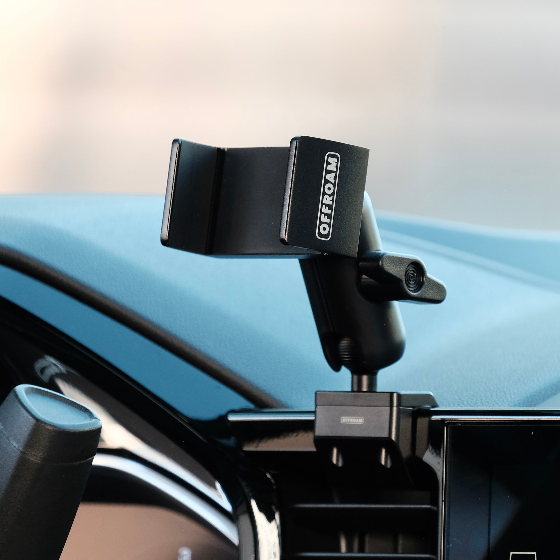 Image of Offroam Phone Mount installed securely in Chevrolet Silverado 2022-2025 | Silverado HD 2024-2025 and GMC Sierra 1500 2022-2025 | Sierra HD 2024-2025 with 13.4-in. display. This premium phone mount installs easily without drilling or glue. Spring loaded Universal holder for use with any phone. Perfect placement without blocking screens, driver view, or air flow. Fully adjustable positioning.