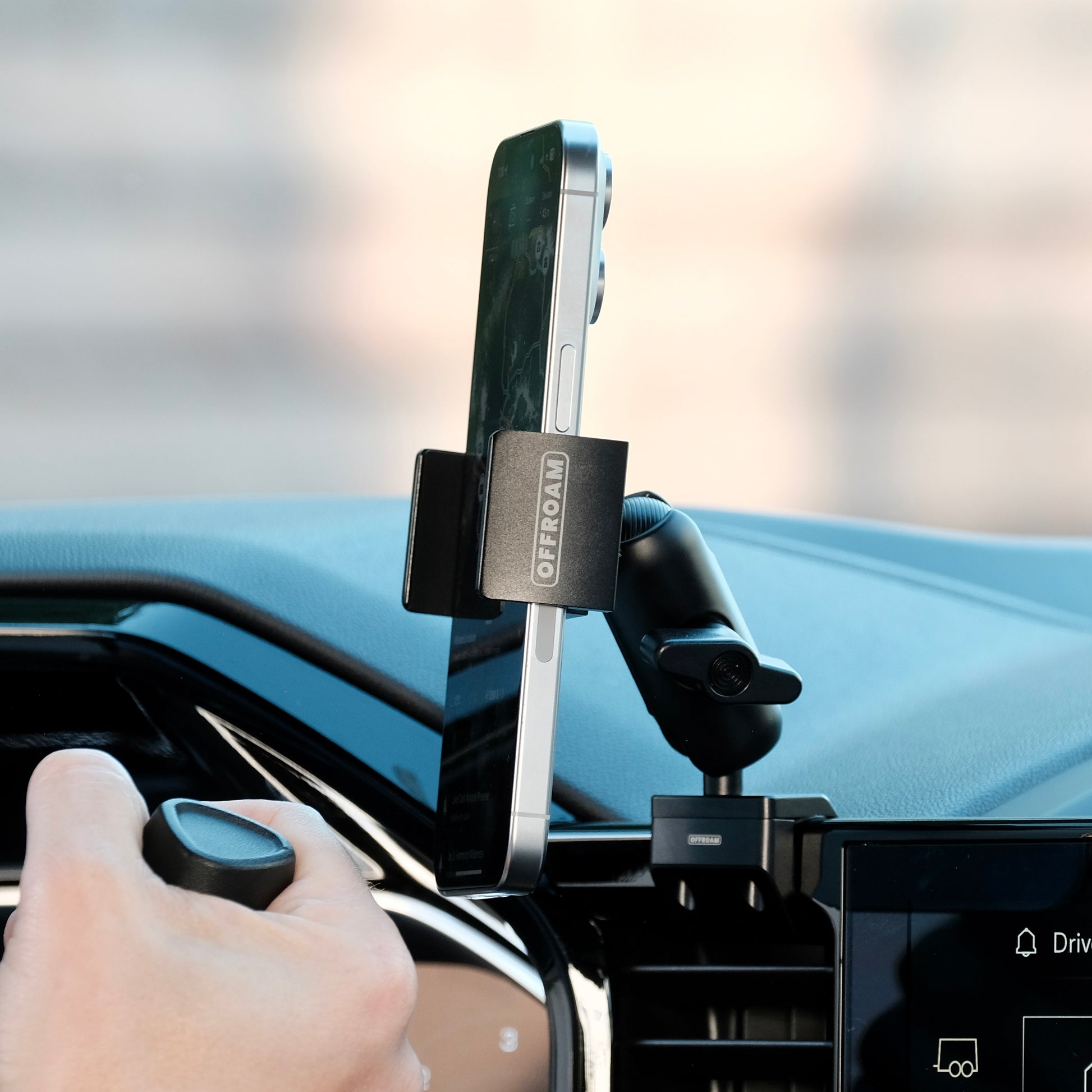 Image of Offroam Phone Mount installed securely in Chevrolet Silverado 2022-2025 | Silverado HD 2024-2025 and GMC Sierra 1500 2022-2025 | Sierra HD 2024-2025 with 13.4-in. display. This premium phone mount installs easily without drilling or glue. Spring loaded Universal holder for use with any phone. Perfect placement without blocking screens, driver view, or air flow. Fully adjustable positioning.