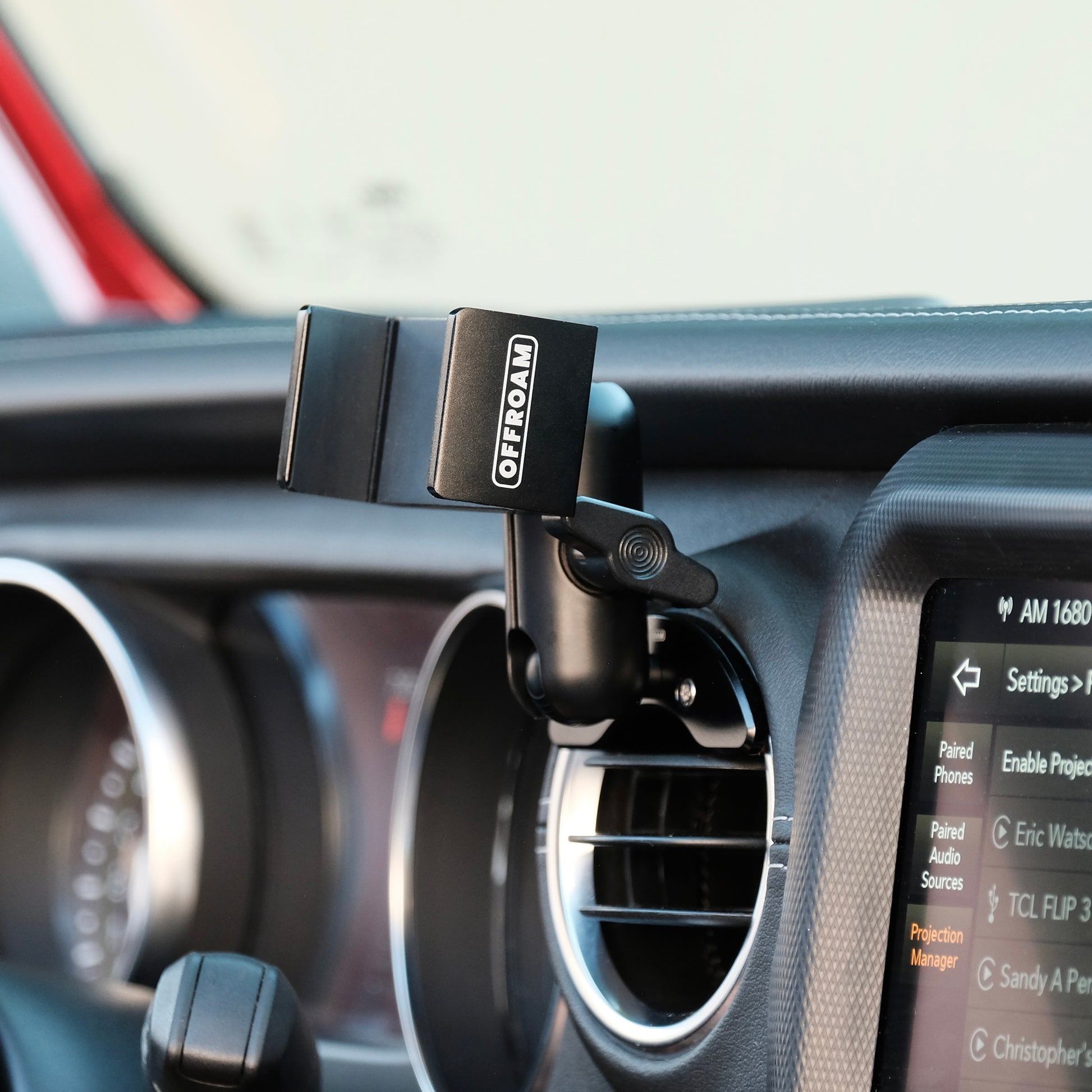 Image of Offroam Phone Mount installed securely in Jeep Wrangler 2018-2023 | Gladiator 2019-2023. This premium phone mount installs easily without drilling or glue. Spring loaded Universal holder for use with any phone. Perfect placement without blocking screens, driver view, or air flow. Fully adjustable positioning.