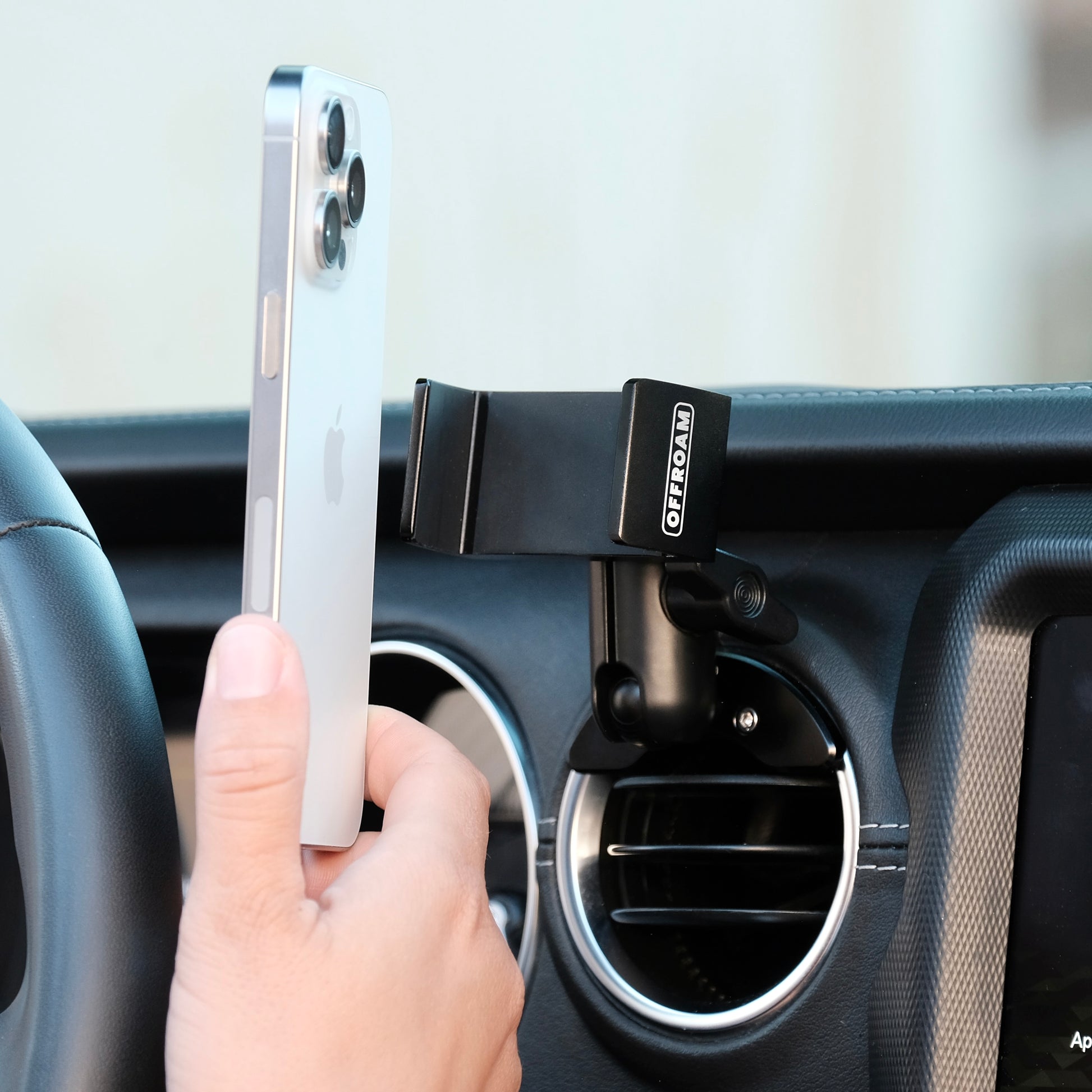 Image of Offroam Phone Mount installed securely in Jeep Wrangler 2018-2023 | Gladiator 2019-2023. This premium phone mount installs easily without drilling or glue. Spring loaded Universal holder for use with any phone. Perfect placement without blocking screens, driver view, or air flow. Fully adjustable positioning.