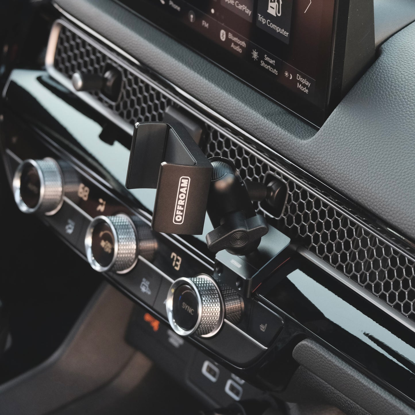 Image of Offroam Phone Mount installed securely in Honda Civic 2022-2026 | CR-V 2023-2026. This premium phone mount installs easily without drilling or glue. Spring loaded Universal holder for use with any phone. Perfect placement without blocking screens, driver view, or air flow. Fully adjustable positioning.
