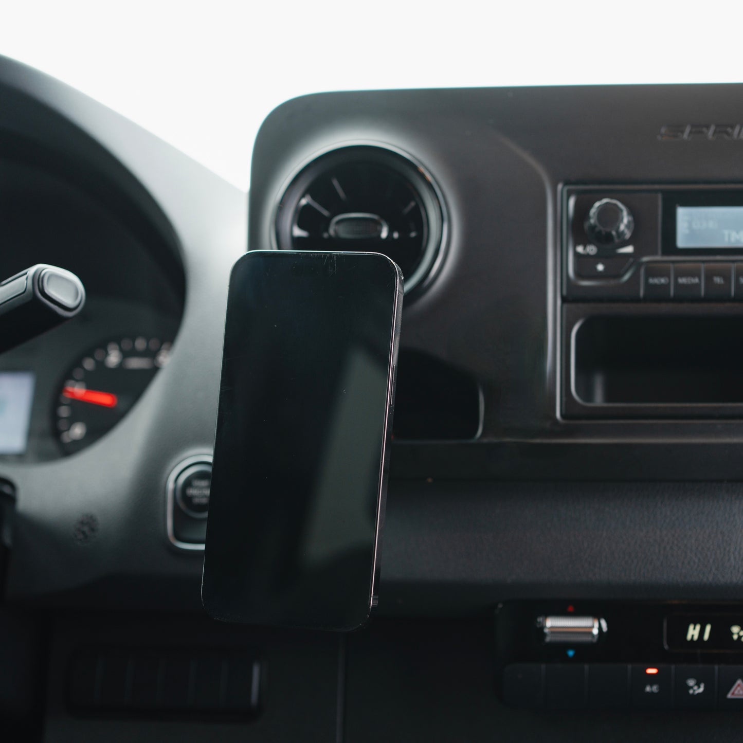 Image of Offroam MagSafe-compatible Phone Mount installed securely in Mercedes-Benz Sprinter 2019-2025. This premium phone mount installs easily without drilling or glue. High force magnets hold phone on any trail, road, or track. Perfect placement without blocking screens, driver view, or air flow. Fully adjustable positioning.