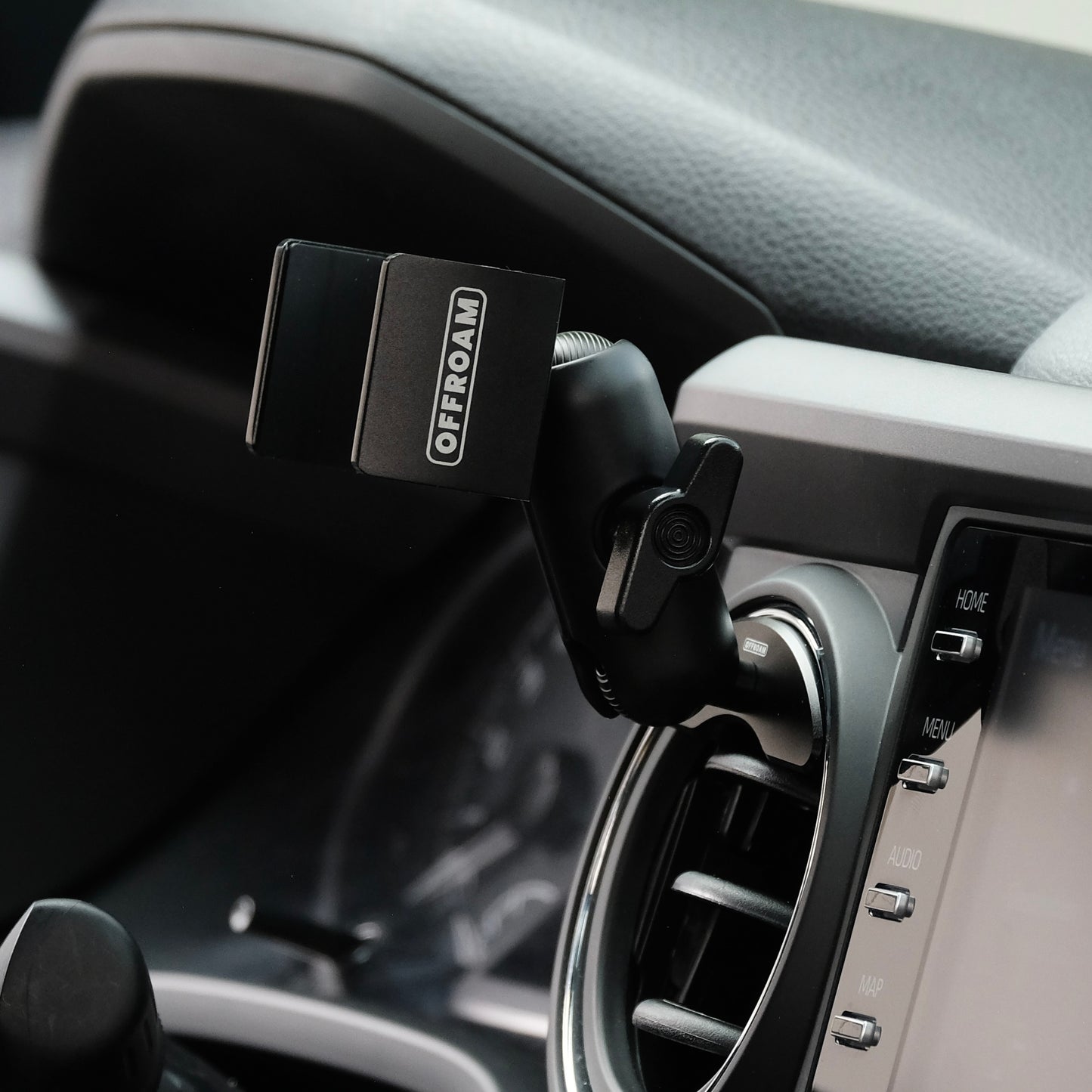 Offroam phone mount securely installed in 2016-2023 Toyota Tacoma or 2014-2021 Toyota Tundra. Vehicle-specific mounting base with 20mm ball coupled to a a double socket arm and a universal holder. Shown from a side without a phone in place