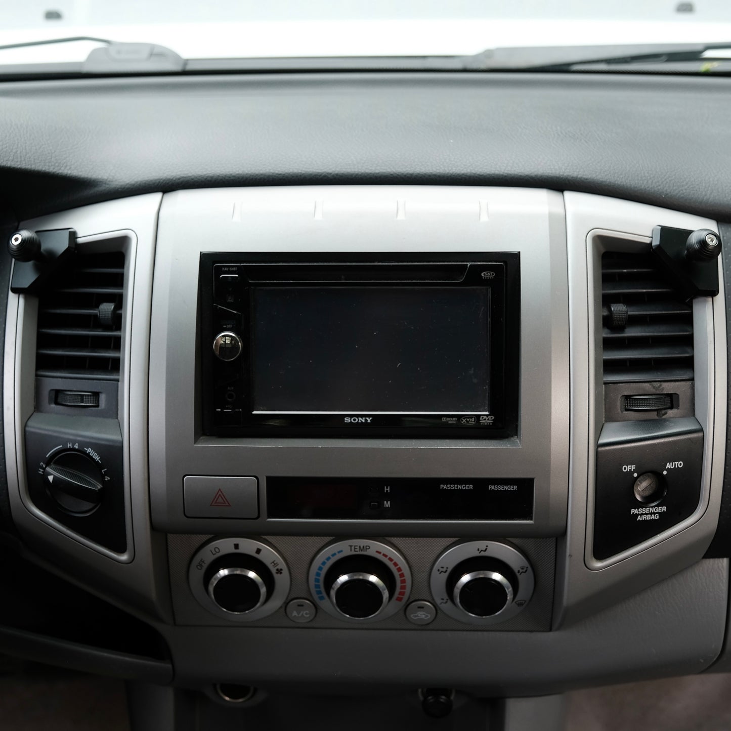 Image of Offroam Mounting Bases installed securely in Toyota Tacoma 2005-2011. This premium all metal phone mounting base installs easily without drilling or glue. Perfect placement without blocking screens, driver view, or air flow.