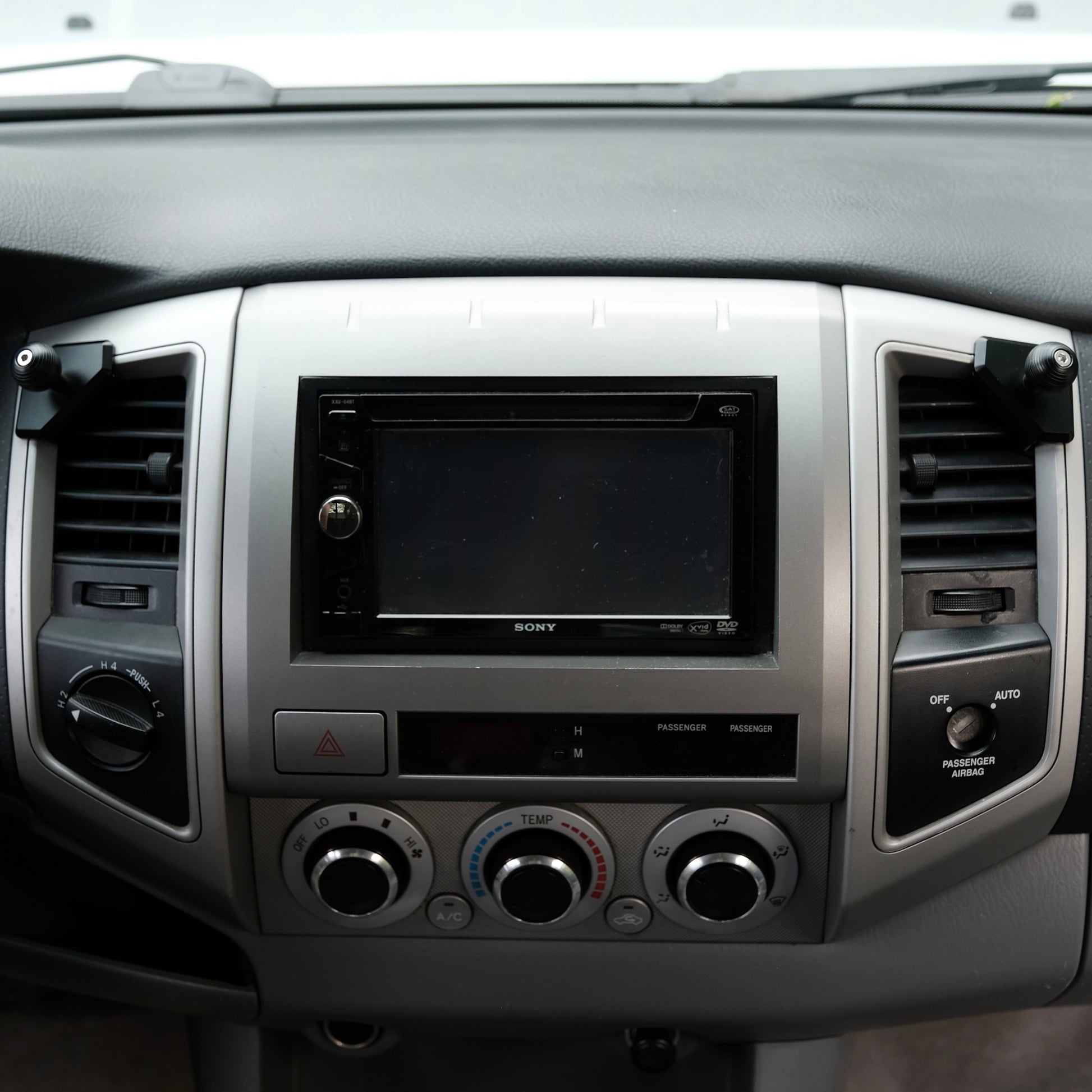 Image of Offroam Mounting Bases installed securely in Toyota Tacoma 2005-2011. This premium all metal phone mounting base installs easily without drilling or glue. Perfect placement without blocking screens, driver view, or air flow.