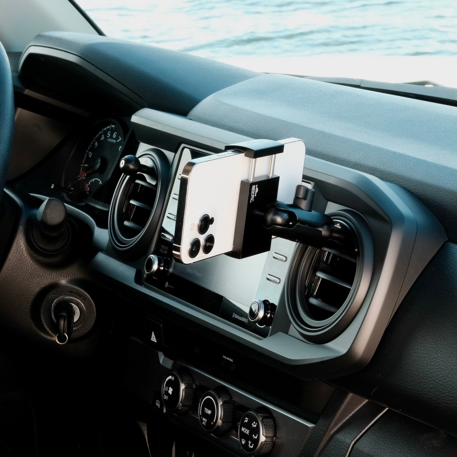 Image of Offroam Phone Mount installed securely in Toyota Tacoma 2016-2023 | Tundra 2014-2021. This premium phone mount installs easily without drilling or glue. Spring loaded Universal holder for use with any phone. Perfect placement without blocking screens, driver view, or air flow. Fully adjustable positioning.