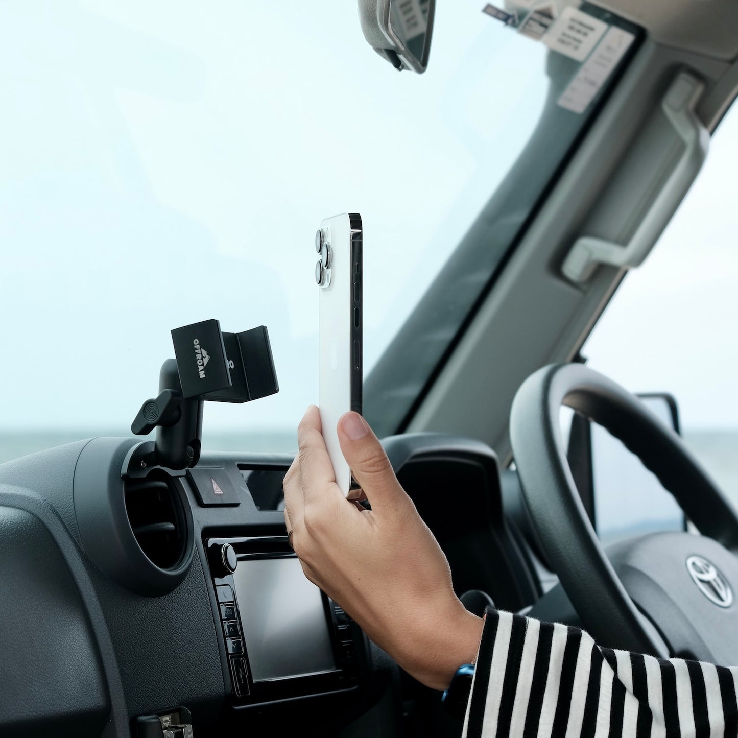 Image of Offroam Phone Mount installed securely in Toyota Land Cruiser 70 2007-2026. This premium phone mount installs easily without drilling or glue. Spring loaded Universal holder for use with any phone. Perfect placement without blocking screens, driver view, or air flow. Fully adjustable positioning.