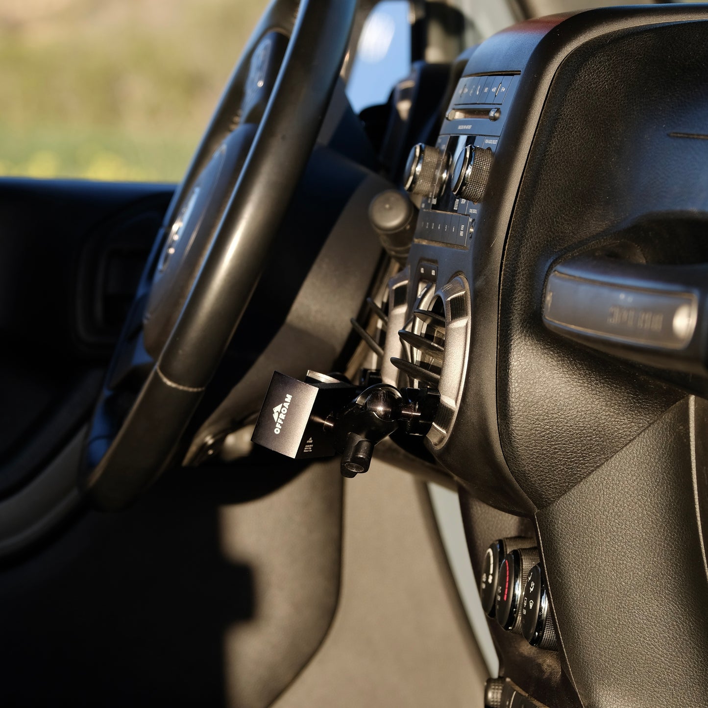 Image of Offroam Phone Mount installed securely in Jeep Wrangler JK 2011-2018. This premium phone mount installs easily without drilling or glue. Spring loaded Universal holder for use with any phone. Perfect placement without blocking screens, driver view, or air flow. Fully adjustable positioning.