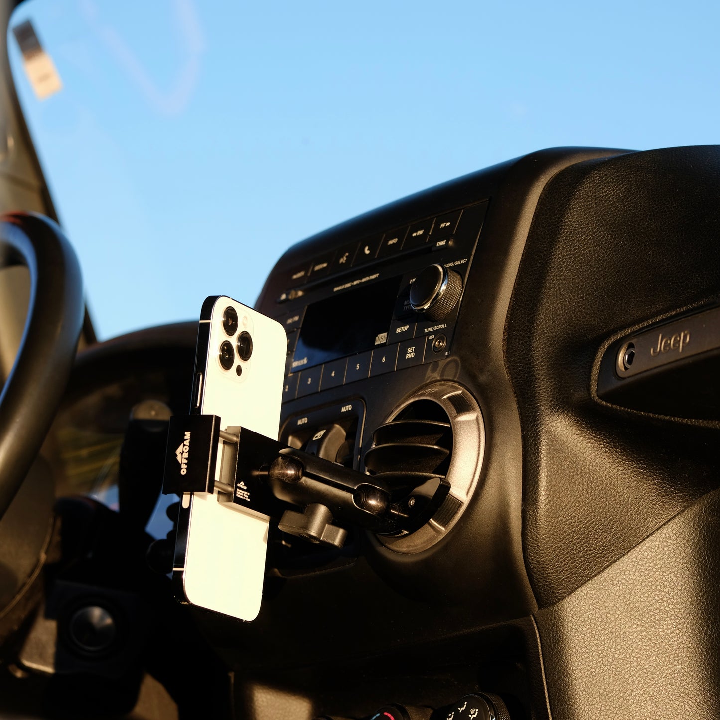 Image of Offroam Phone Mount installed securely in Jeep Wrangler JK 2011-2018. This premium phone mount installs easily without drilling or glue. Spring loaded Universal holder for use with any phone. Perfect placement without blocking screens, driver view, or air flow. Fully adjustable positioning.