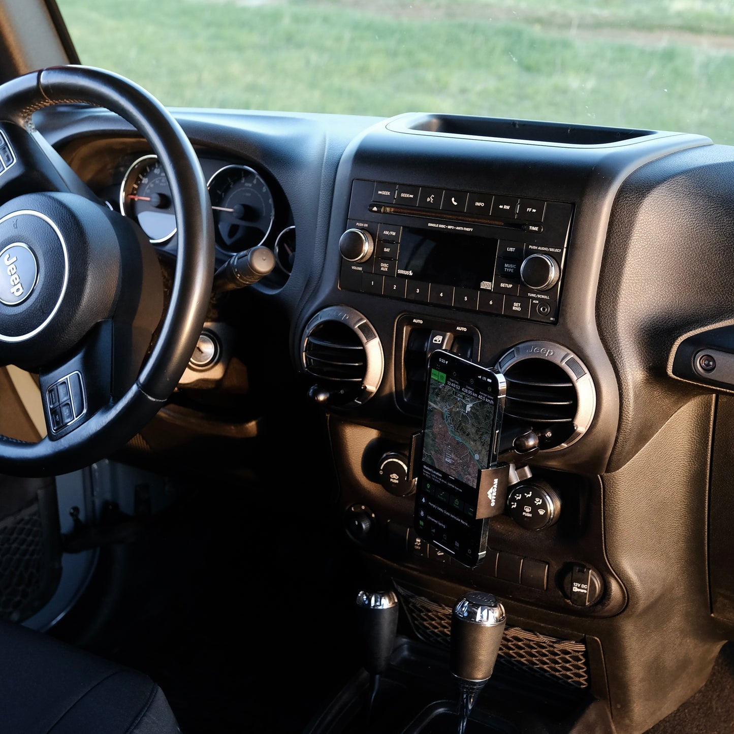 Image of Offroam Phone Mount installed securely in Jeep Wrangler JK 2011-2018. This premium phone mount installs easily without drilling or glue. Spring loaded Universal holder for use with any phone. Perfect placement without blocking screens, driver view, or air flow. Fully adjustable positioning.