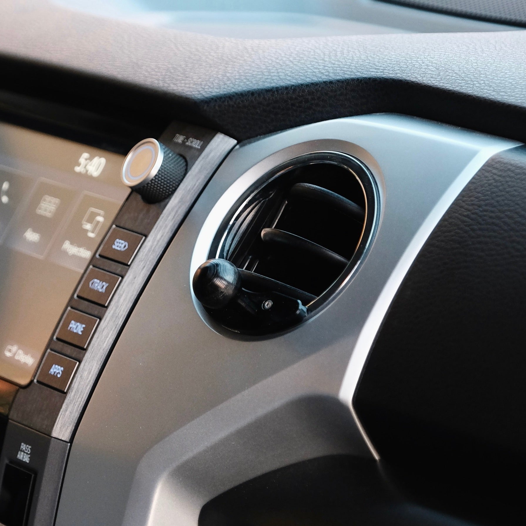 Image of Offroam Mounting Base installed securely in Toyota Tacoma 2016-2023 | Tundra 2014-2021. This premium all metal phone mounting base installs easily without drilling or glue. Perfect placement without blocking screens, driver view, or air flow.