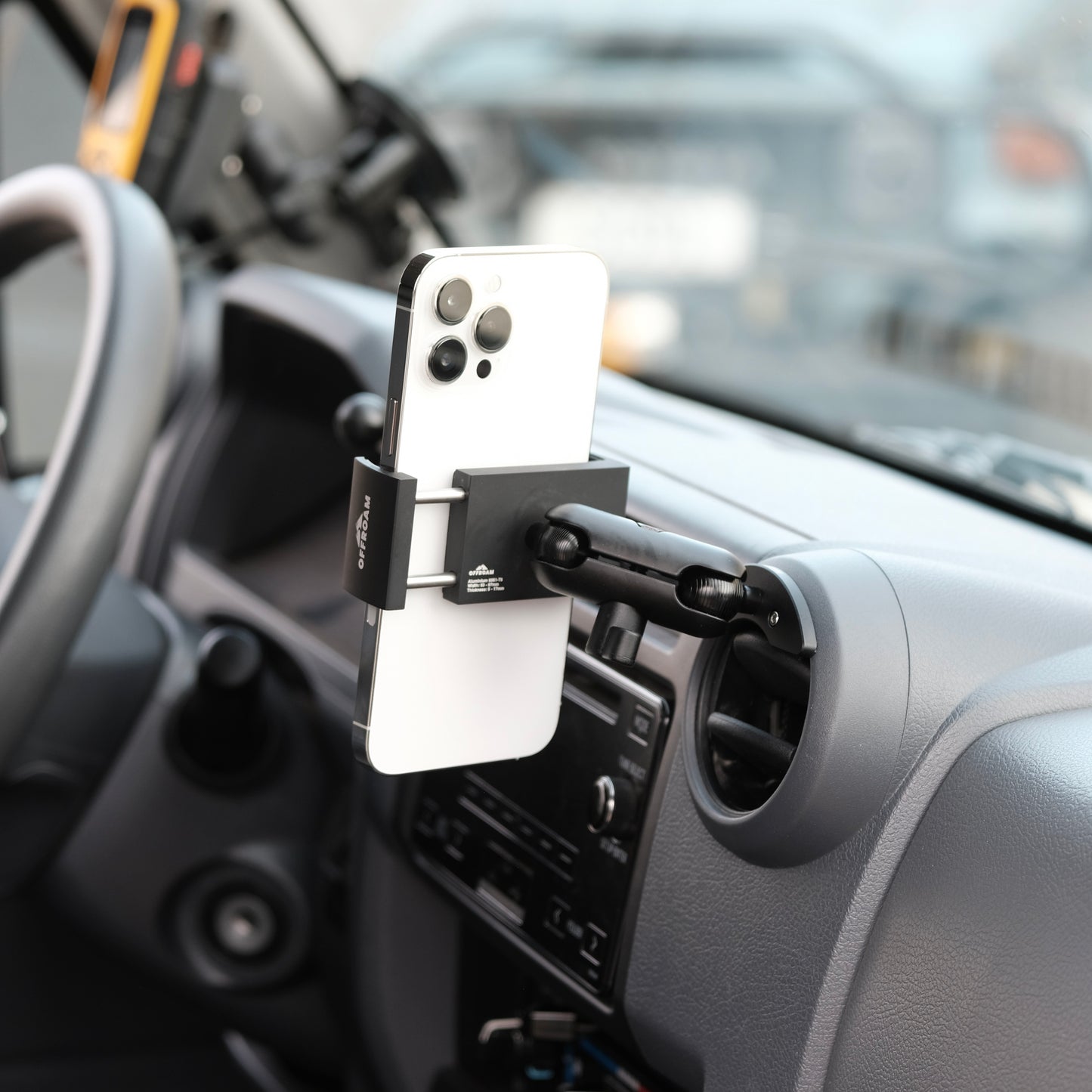 Image of Offroam Phone Mount installed securely in Toyota Land Cruiser 70 2007-2026. This premium phone mount installs easily without drilling or glue. Spring loaded Universal holder for use with any phone. Perfect placement without blocking screens, driver view, or air flow. Fully adjustable positioning.