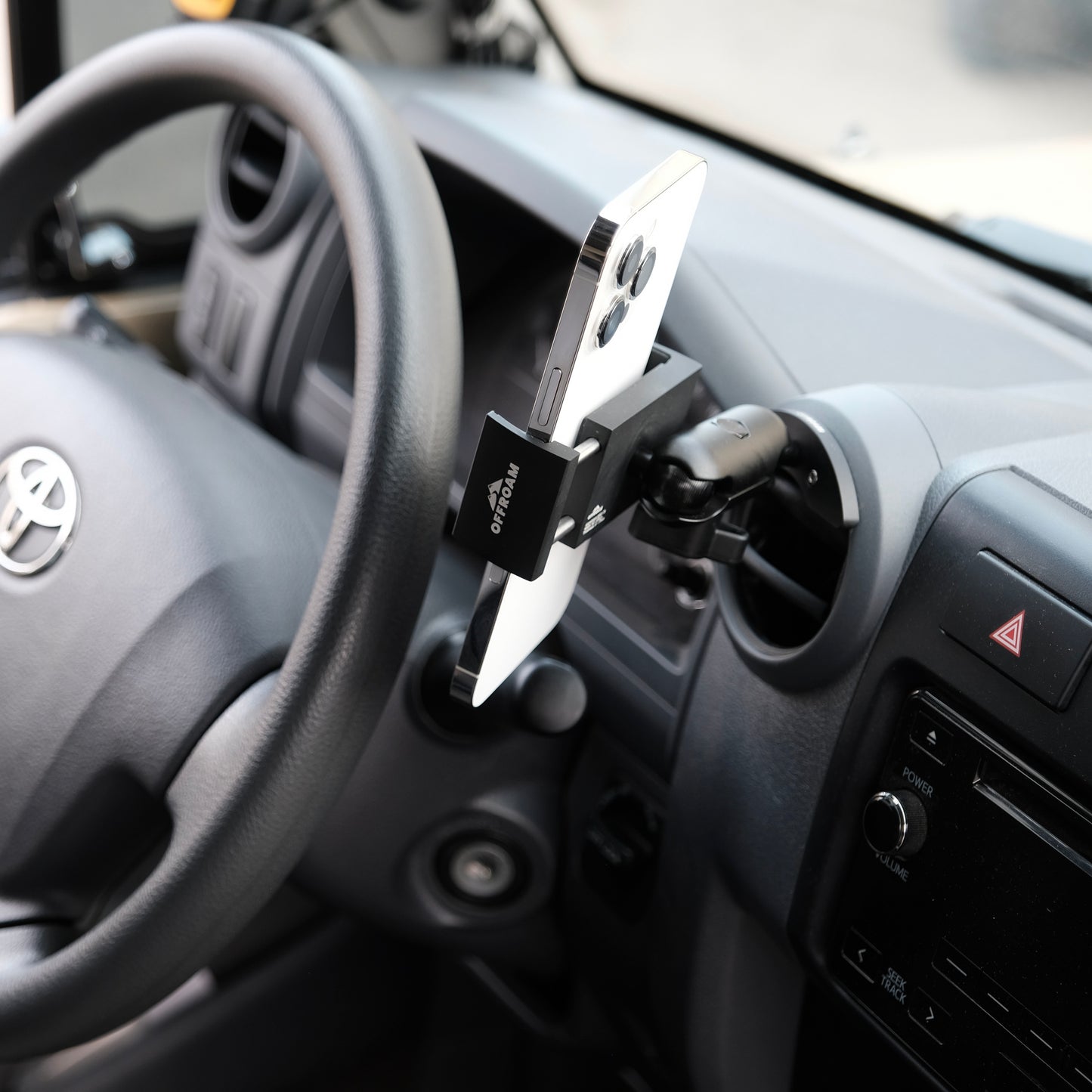 Image of Offroam Phone Mount installed securely in Toyota Land Cruiser 70 2007-2026. This premium phone mount installs easily without drilling or glue. Spring loaded Universal holder for use with any phone. Perfect placement without blocking screens, driver view, or air flow. Fully adjustable positioning.