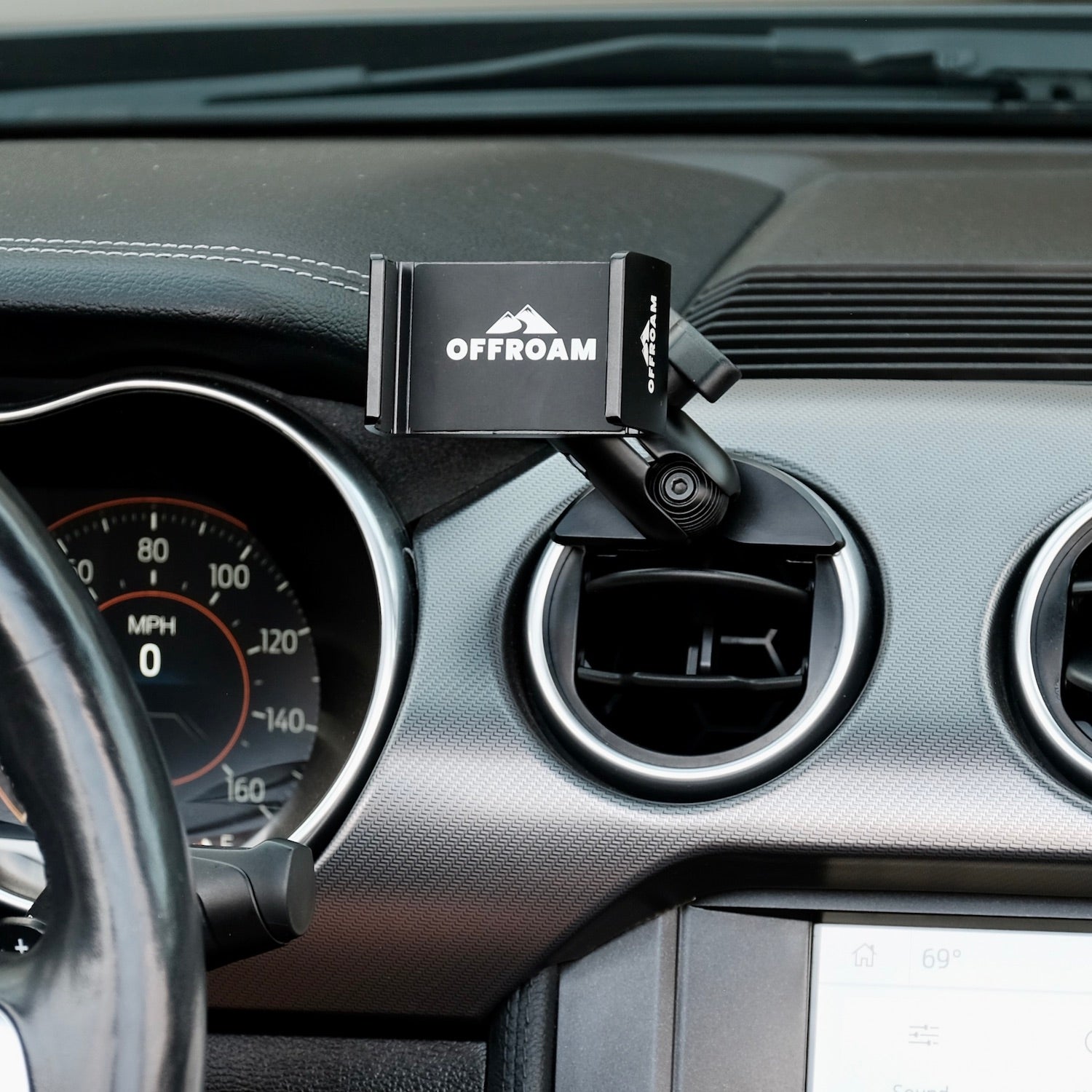 Image of Offroam Phone Mount installed securely in Ford Mustang 2015-2023. This premium phone mount installs easily without drilling or glue. Spring loaded Universal holder for use with any phone. Perfect placement without blocking screens, driver view, or air flow. Fully adjustable positioning.