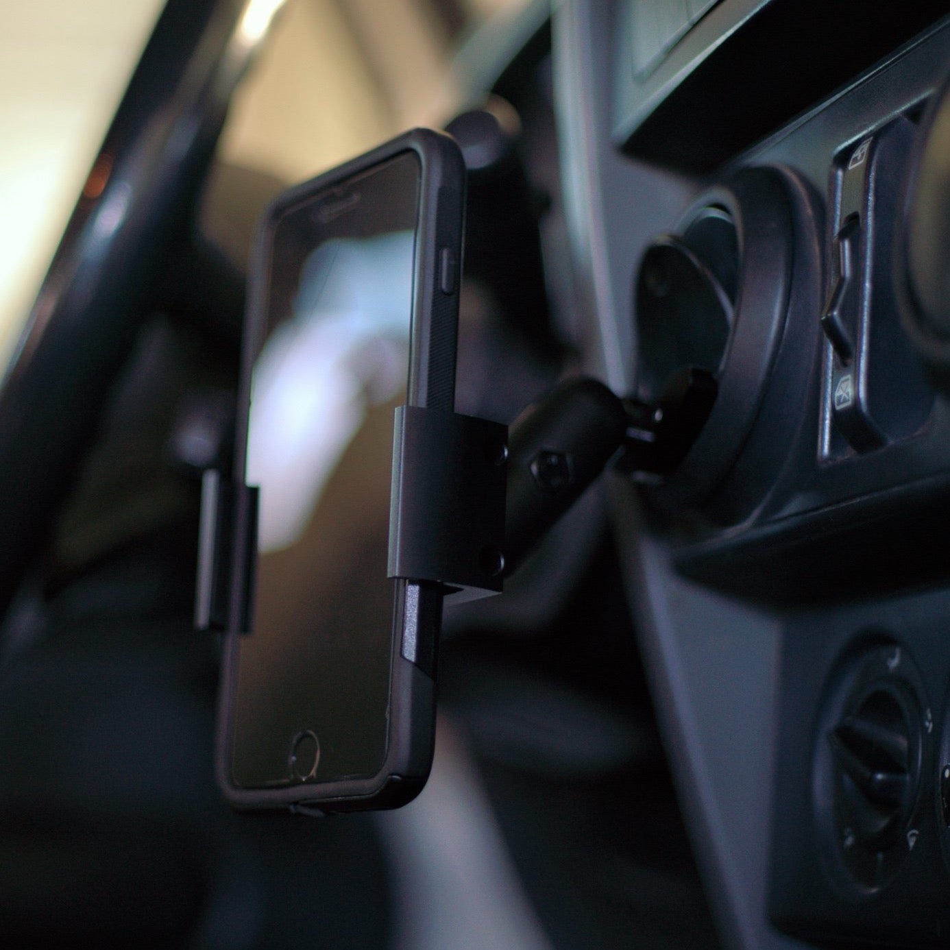 Image of Offroam Phone Mount installed securely in Jeep Wrangler 2007-2010. This premium phone mount installs easily without drilling or glue. Spring loaded Universal holder for use with any phone. Perfect placement without blocking screens, driver view, or air flow. Fully adjustable positioning.