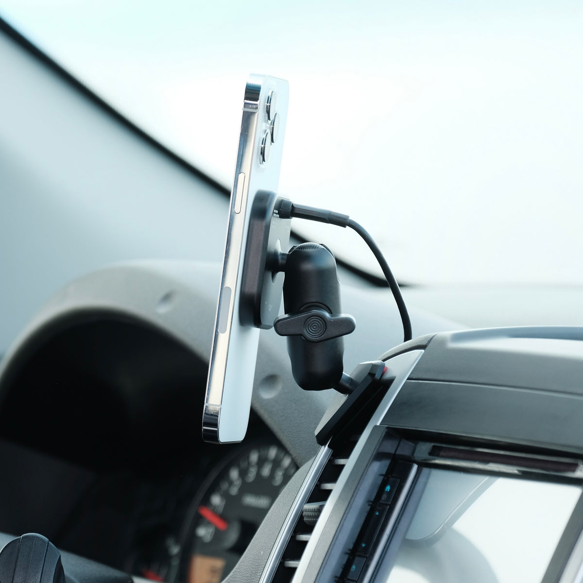 Image of Offroam MagSafe-compatible Qi2 Charging Phone Mount installed securely in Nissan Frontier 2009-2021 | Xterra 2009-2015. This premium phone mount installs easily without drilling or glue. High force magnets hold phone on any trail, road, or track. Perfect placement without blocking screens, driver view, or air flow. Fully adjustable positioning.