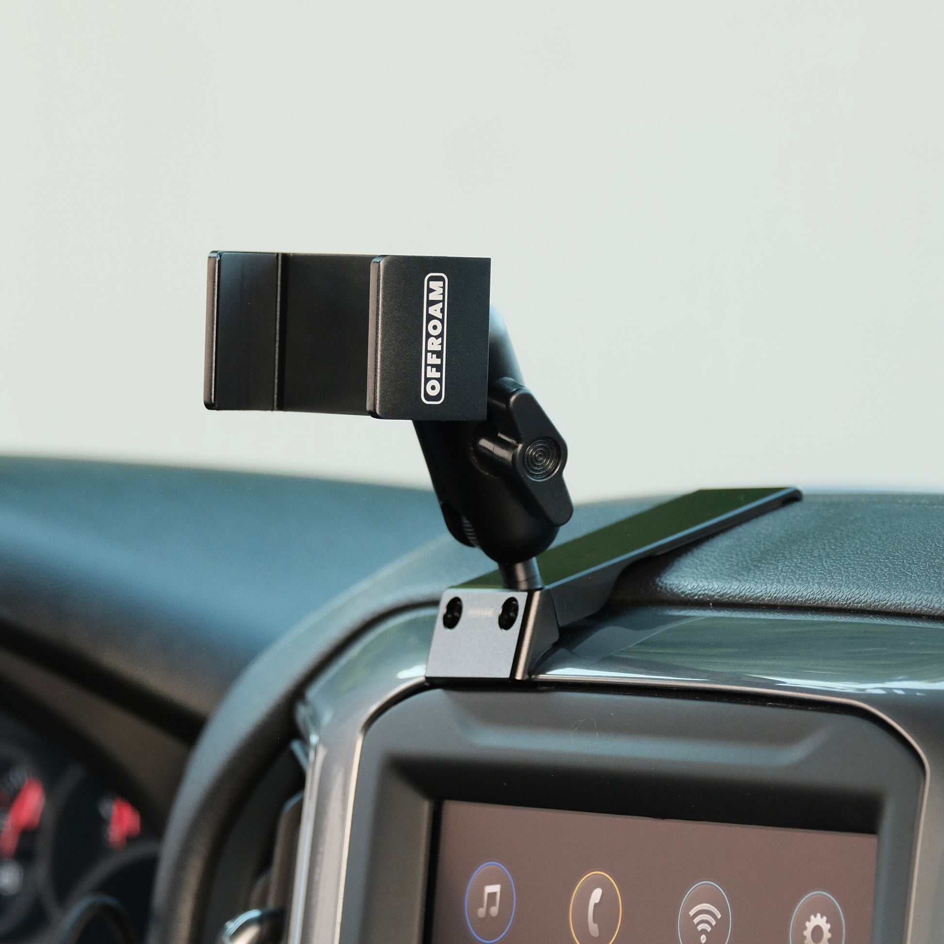 Image of Offroam Phone Mount installed securely in Chevrolet Silverado 2019-2026 | Silverado HD 2020-2026 & GMC Sierra 1500 2019-2026 | Sierra HD 2020-2026 with 7-in.|8-in. display. This premium phone mount installs easily without drilling or glue. Spring loaded Universal holder for use with any phone. Perfect placement without blocking screens, driver view, or air flow. Fully adjustable positioning.