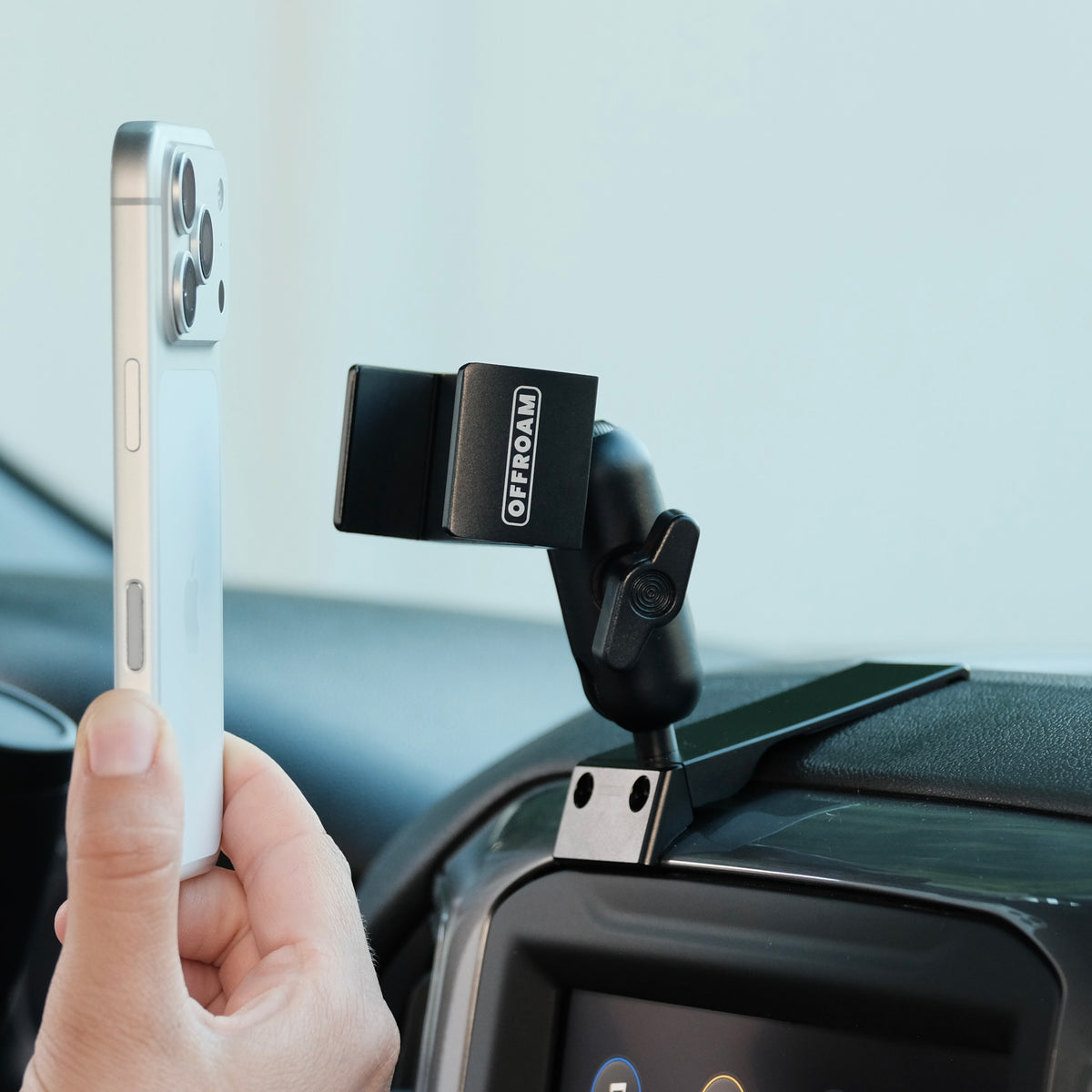 Image of Offroam Phone Mount installed securely in Chevrolet Silverado 2019-2026 | Silverado HD 2020-2026 & GMC Sierra 1500 2019-2026 | Sierra HD 2020-2026 with 7-in.|8-in. display. This premium phone mount installs easily without drilling or glue. Spring loaded Universal holder for use with any phone. Perfect placement without blocking screens, driver view, or air flow. Fully adjustable positioning.