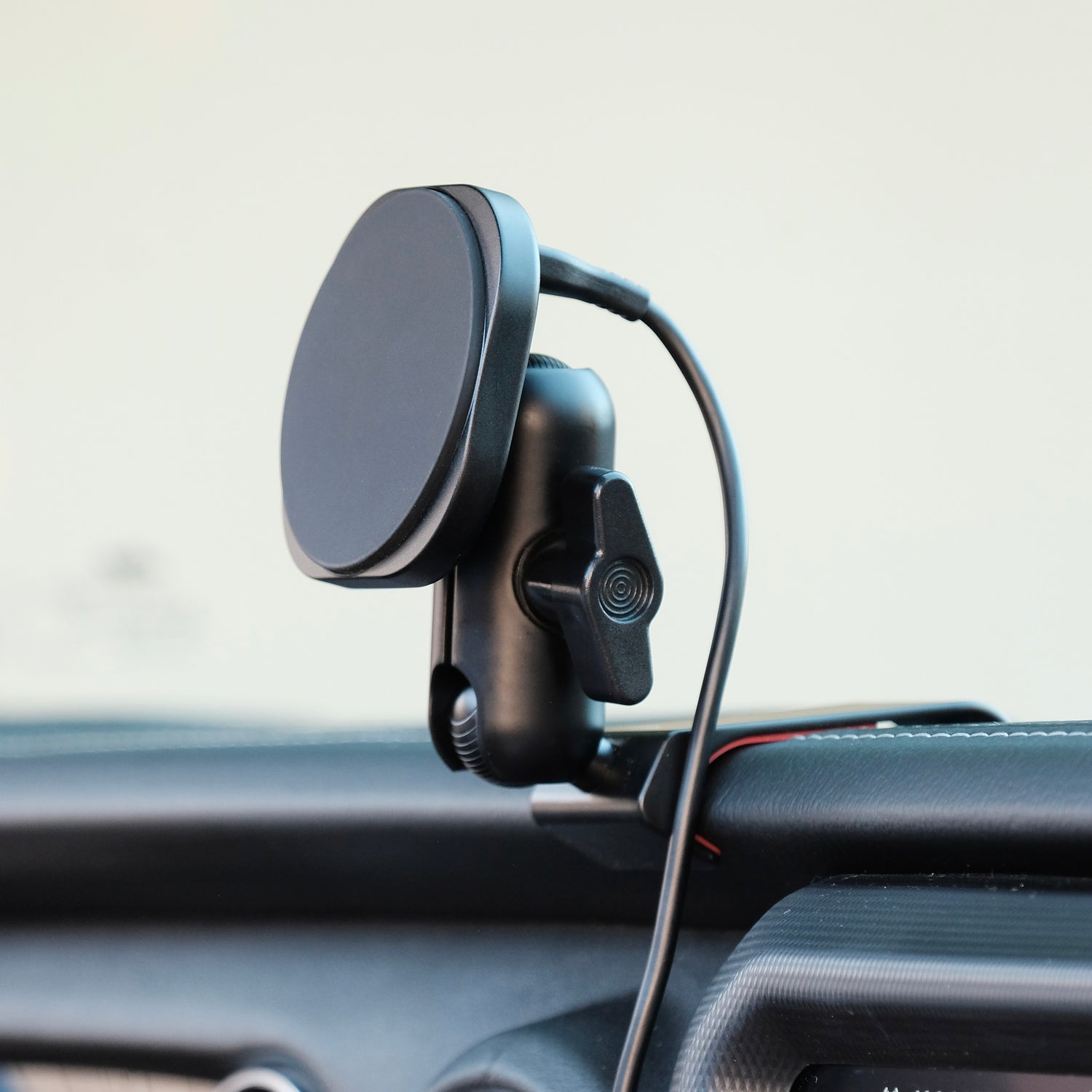 Image of Offroam MagSafe-compatible Phone Mount installed securely in Jeep Wrangler 2018-2023 | Gladiator 2019-2023. This premium phone mount installs easily without drilling or glue. High force magnets hold phone on any trail, road, or track. Perfect placement without blocking screens, driver view, or air flow. Fully adjustable positioning.