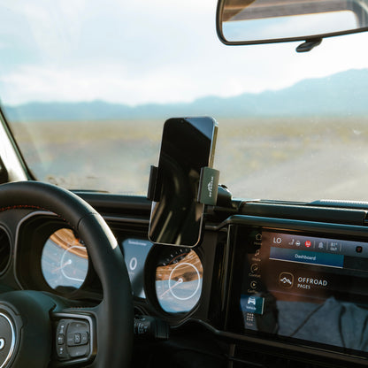 Secure all-metal off-road phone mount—a premium Jeep accessory—installed in a 2024-2025 Jeep Wrangler or Jeep Gladiator, holding a smartphone with a spring-loaded holder for optimal positioning during off-road exploration.