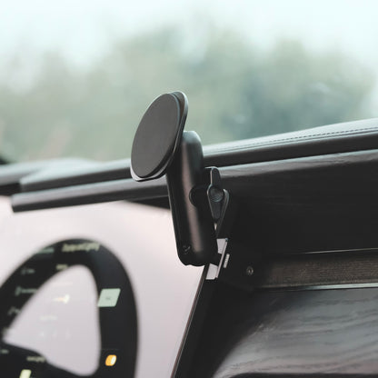 A magsafe phone holder securely installed on passenger side of Rivian R1T R1S behind the screen using existing features of the dashboard. The phone mount has a mounting base shaped to fit the Rivian, a coupling arm, and the phone holder.