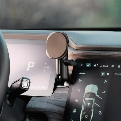 A magsafe phone holder securely installed in Rivian R1T R1S behind the screen using existing features of the dashboard. The phone mount has a mounting base shaped to fit the Rivian, a coupling arm, and the phone holder.