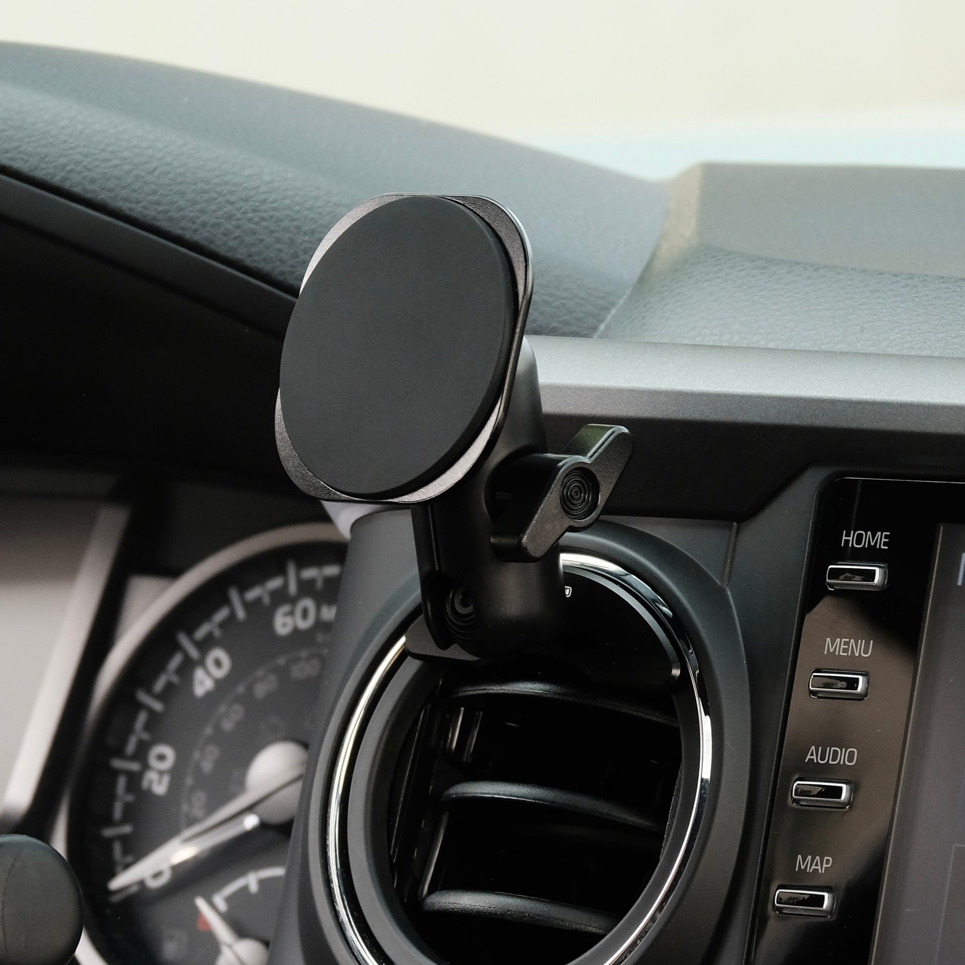 Offroam phone holder attached securely to Toyota Tacoma 2016-2023 air vent bezel with integrated 20mm ball mount interface. Showing Offroam articulating arm and a non-charging MagSafe-compatible holder with strong magnets.