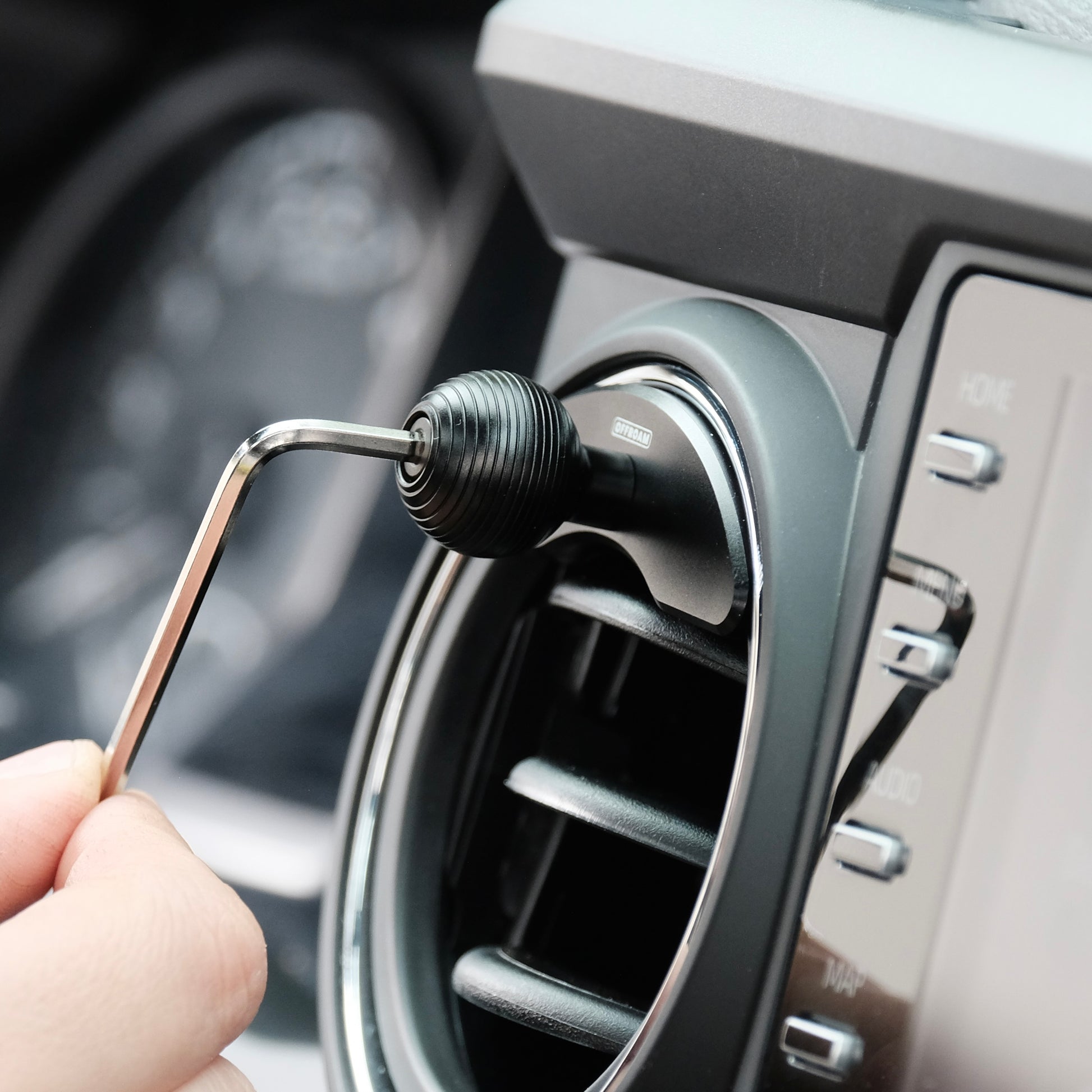 Offroam mounting base with 20mm ball installed securely in Toyota Tacoma 3rd gen air vent bezel using Allen key. Securely clamps to bezel for strong hold