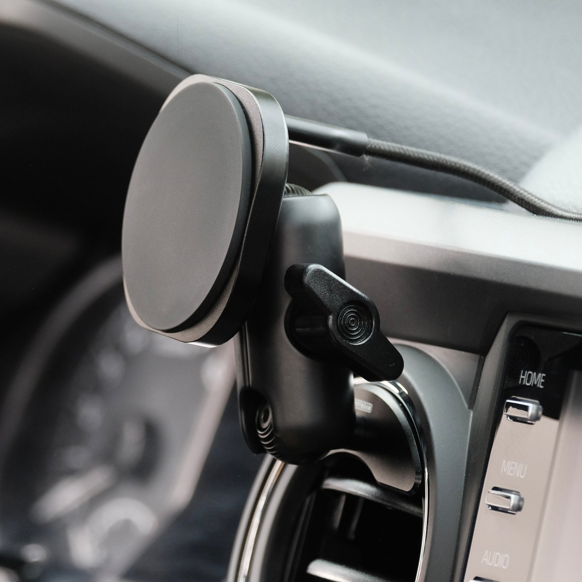 Offroam phone mount installed securely in a Toyota Tacoma 2016 to 2023 or Toyota tundra 2014 to 2021 model years. Showing vehicle specific mounting base with 20 mm ball, a coupling arm and a G2 charging holder with the cable exiting on the rear for clean cable management secure MagSafe compatible magnets inside.