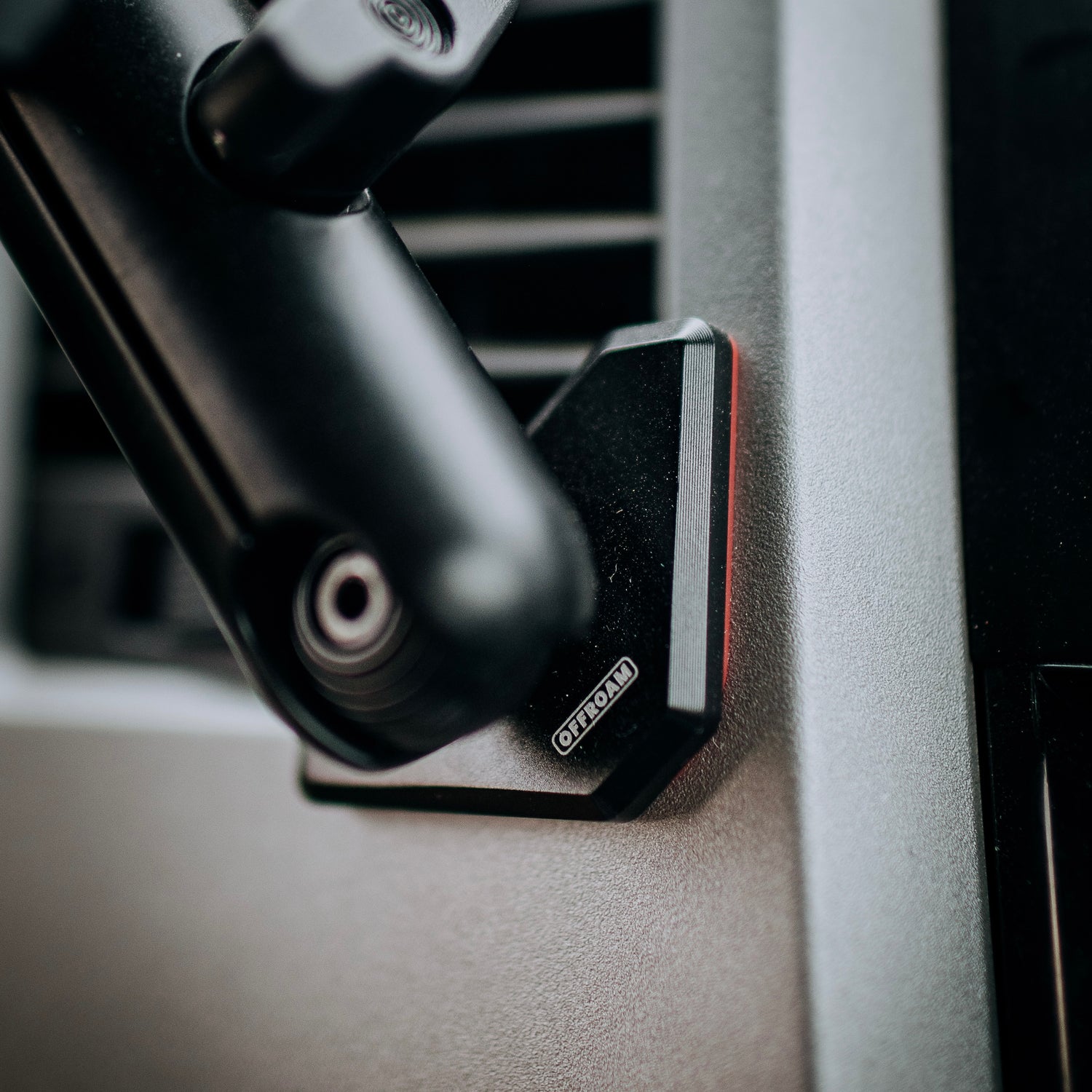 Offroam mounting base installed in a 2nd generation Tundra. Shown up close with a coupling arm attached the details highlight all-metal construction and peek-a-boo view of a rubber liner that protects the 2007-2013 Tundra Dashboard from damage.