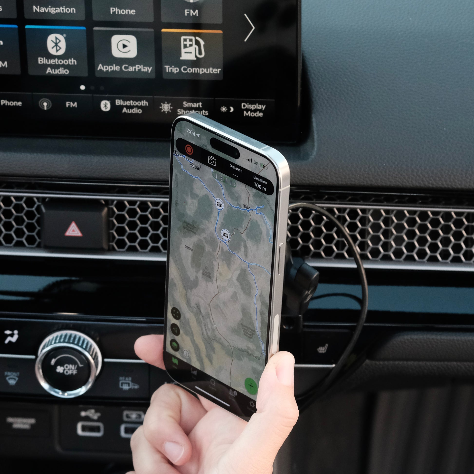 MagSafe-compatible Qi2 phone mount installed in a 2022–2025 Honda Civic / 2023–2025 CR-V, with phone held next to mount to show ideal placement that avoids blocking screen or airflow.